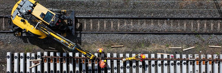 Arbeiter und Baufahrzeug an Schwellen und Schienen bei Gernsheim.