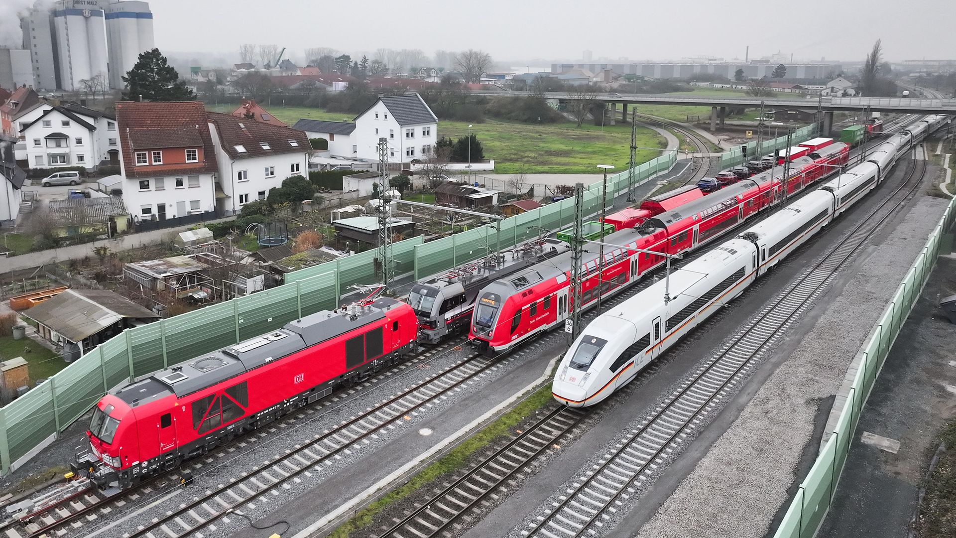 Drei Züge, ein Güterzug, ein Regionalzug und ein ICE, sind aus der Luftperspektive am Bahnhof Gernsheim fotografiert