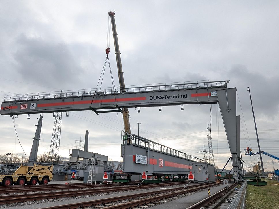 Ein Kran hebt den Träger des neuen Containerkrans in die Höhe