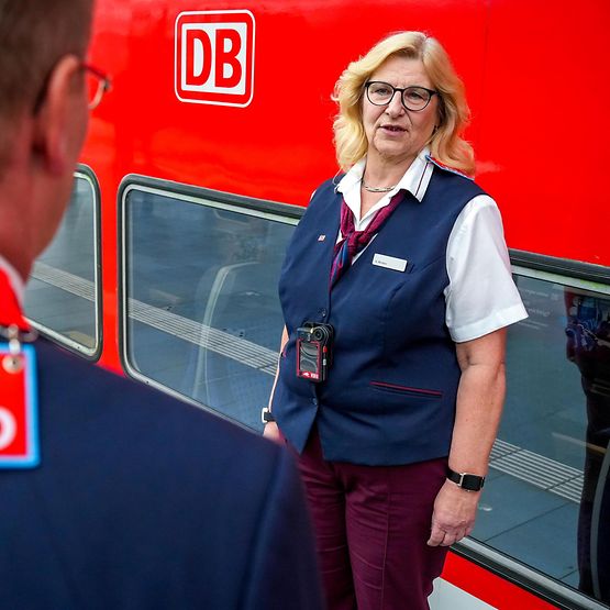 Zwei Mitarbeitende der DB mit Bodycams vor einem Zug