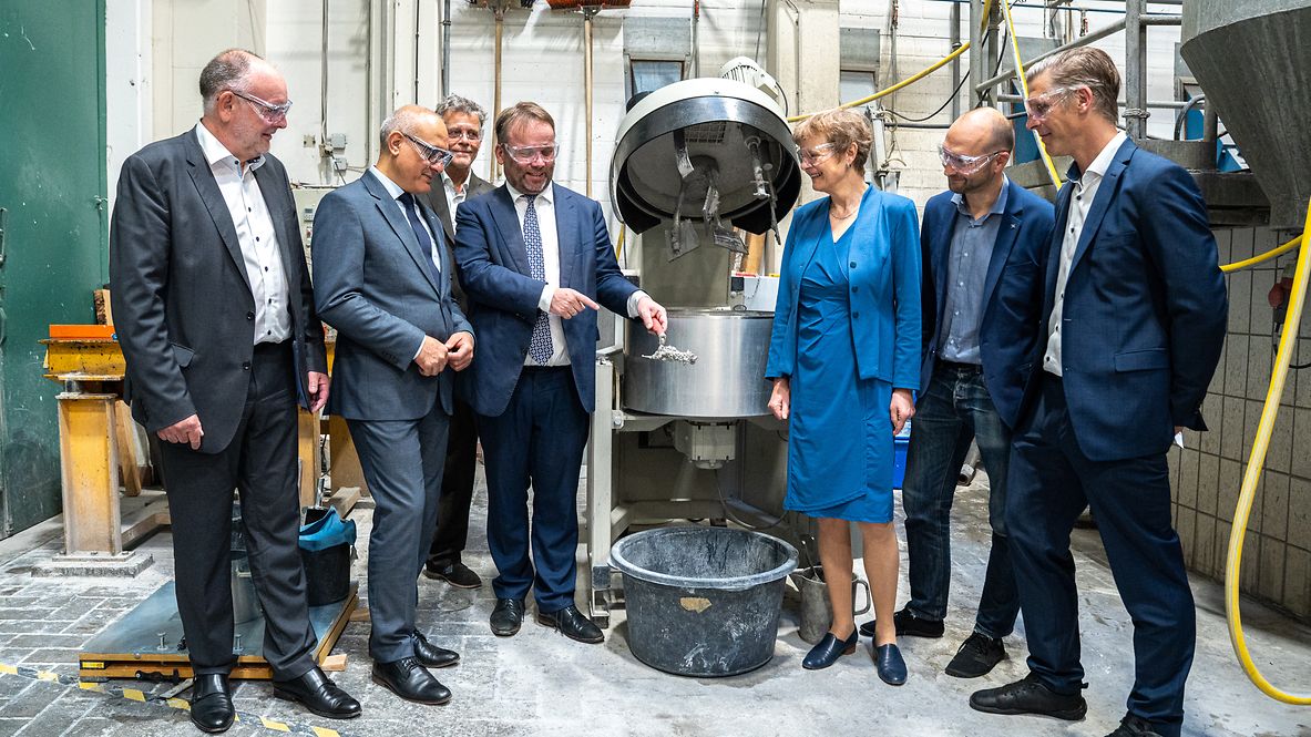 Teilnehmende des Pressetermins Ökobeton neben Betonmischer