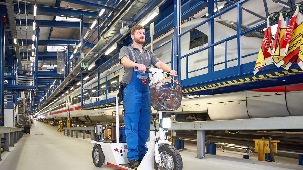 An employee is riding an e-scooter around the factory.