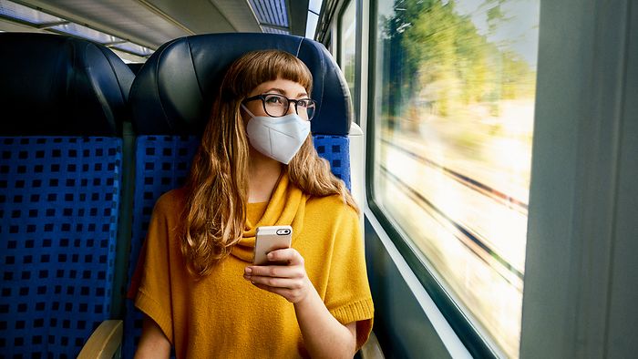Frau im Zug mit FFP2-Maske