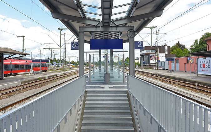 Treppenaufgang einer Verkehrsstation mit überdachtem Mittelbahnsteig